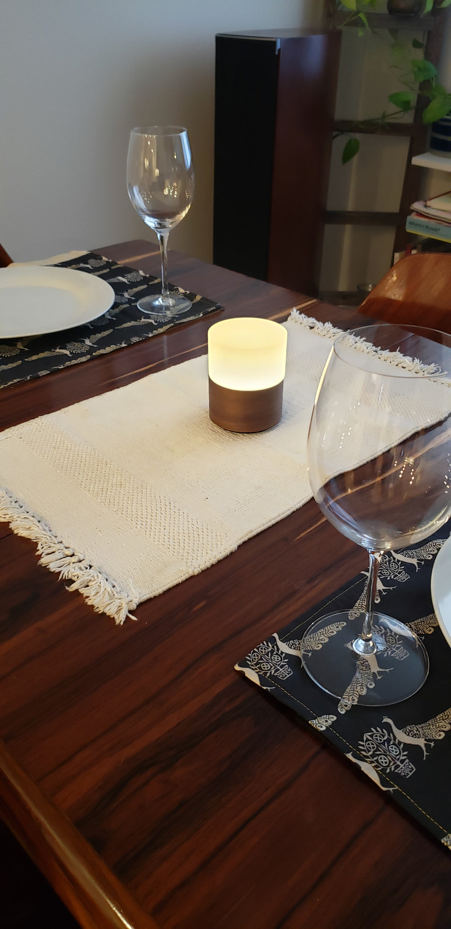 Ola Walnut resting on dining room table with dinner setting and wine glasses.