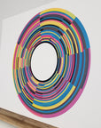 Right-hand view of print entitled 'Clocks' resting on wood shelf.