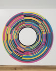 Front view of print entitled 'Clocks' resting on wood shelf.