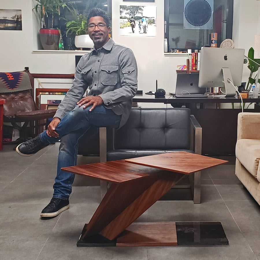 Artist and designer, Jason Robinson, sits behind his creation, Canopy Table. 