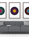 Print series entitled 'Penumbra Triptych' in black frames mounted on living room wall.