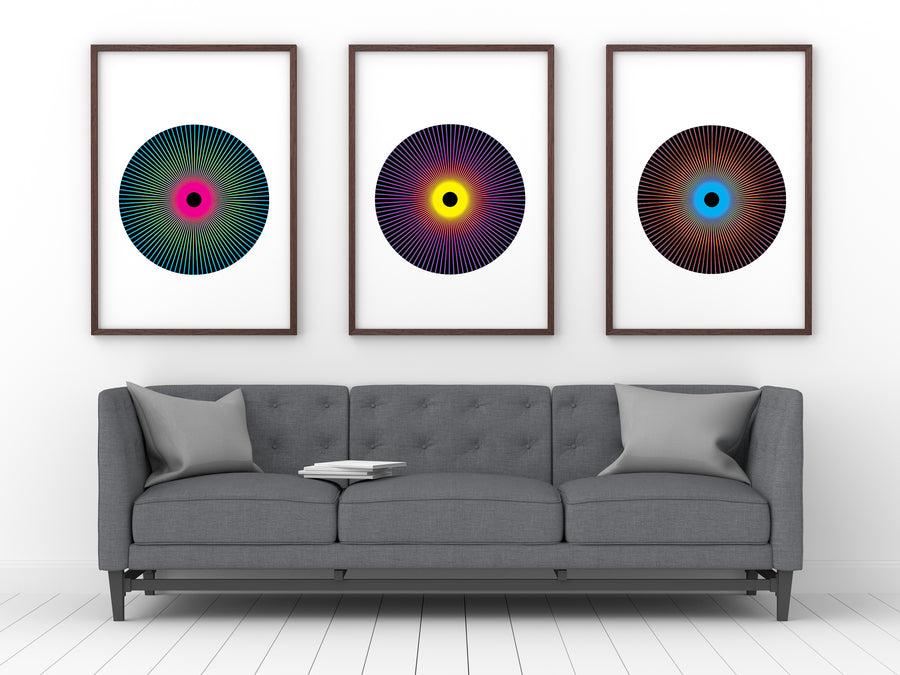 Print series entitled 'Penumbra Triptych' in black frames mounted on living room wall.
